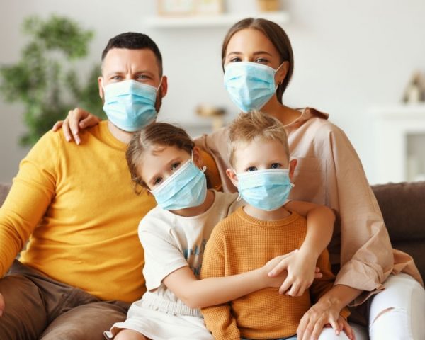 happy family in protective medical masks in the midst of the coronavirus pandemic at home